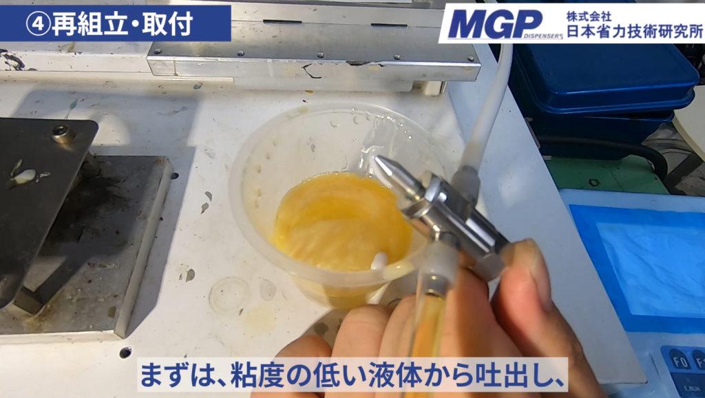 ミキサーカートリッジの泡抜き作業。粘度の低い液体から吐出し、容器に受ける様子。
